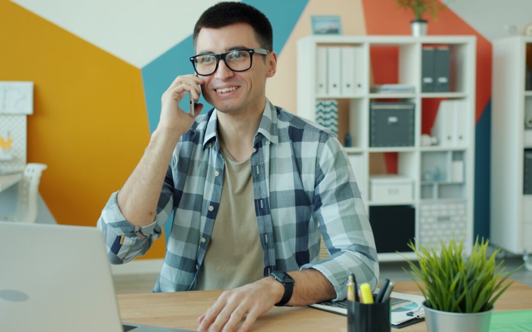 Man in glasses talking on phone at desk